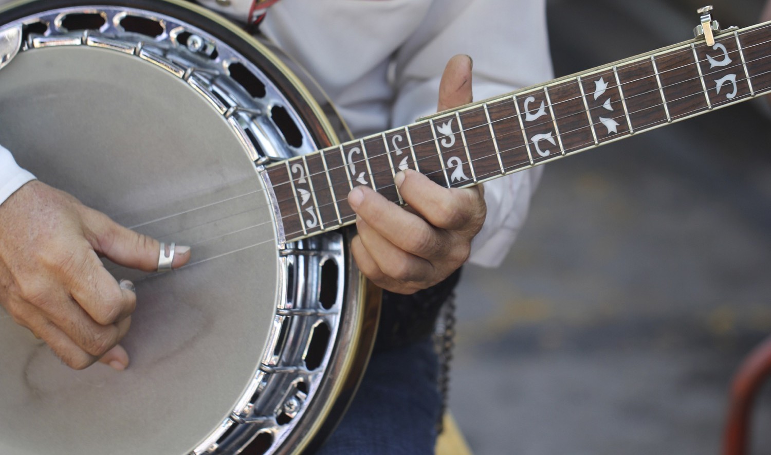 Close up image of a man's hands playing the banjo.